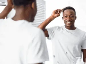 man in white shirt brushing his hair
