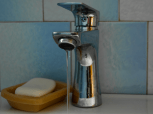 soap beside a faucet with running water