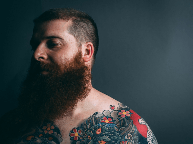man with beard and body tattoo