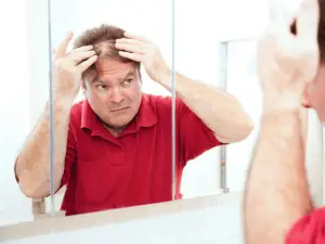man in red shirt facing a mirror