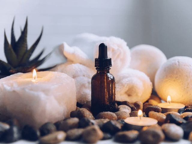 bottle of essential oil with candles