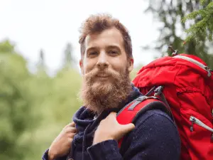 man carrying red backpack
