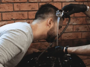 man washing beard in a salon