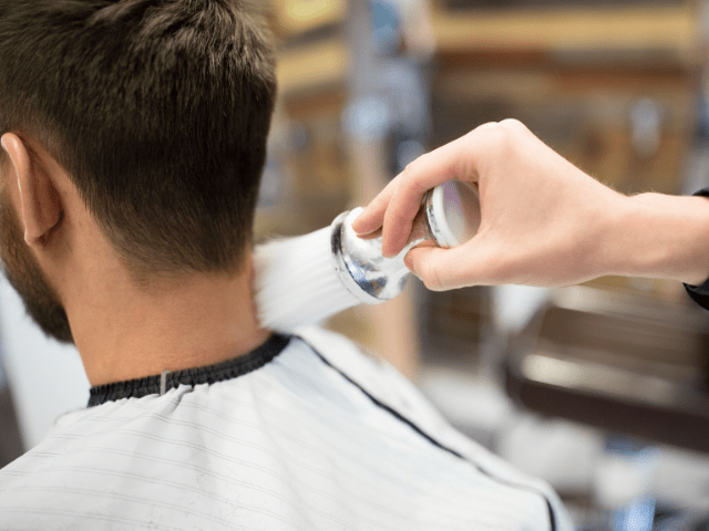 barber using neck duster brush to a man