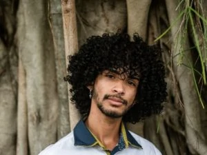 man with curly hair wearing a polo shirt